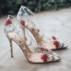 a pair of high heeled shoes with flowers painted on them
