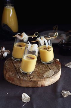three glasses filled with pudding sitting on top of a wooden table