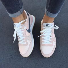 a person's feet with white and blue sneakers on top of their shoes,