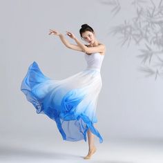 a woman in a blue and white dress is dancing with her arms spread out to the side