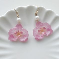 pink flower and pearl earrings on a white plate