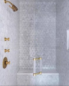 an instagram photo of a bathroom with gold fixtures and white marble tiles on the walls