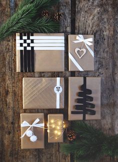 presents wrapped in brown paper with white ribbons and bows are sitting on a wooden table