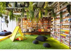 an indoor library with bookshelves and plants growing on the walls, green carpeted flooring