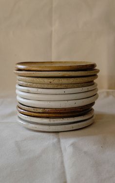 a stack of white and brown plates sitting on top of each other