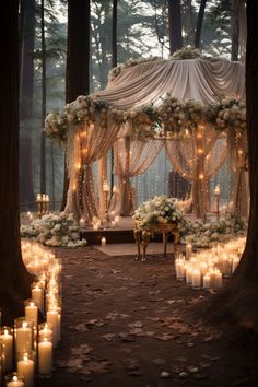 an outdoor wedding setup with candles and flowers on the ground, surrounded by tall trees