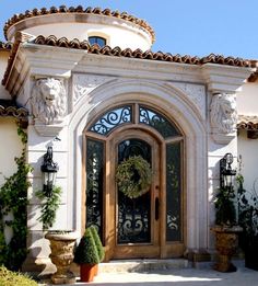 the front entrance to a home with potted plants