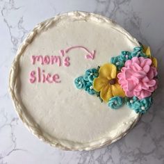 there is a cake that says mom's slice with flowers on the bottom and pink, blue, yellow and green icing