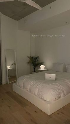a white bed sitting on top of a wooden floor