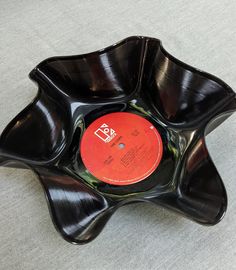 a record in a black bowl on the floor