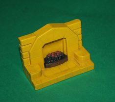 a yellow toy fireplace on a green surface