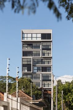 a tall building with lots of windows on top of it's sides and trees in the foreground