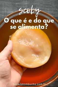a person holding an apple in a bowl with the words como fazer kompucha, a partir do zero com detailes