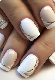 a woman's nails with white and gold designs