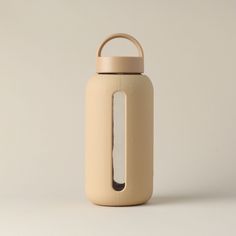 a white and beige bottle with a handle on the top is standing in front of a plain background