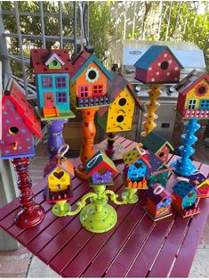 colorful birdhouses and telephones on a table outside