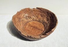 a wooden bowl sitting on top of a white table