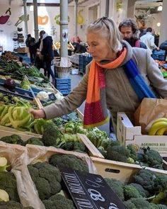 an older woman is shopping for fruits and vegetables