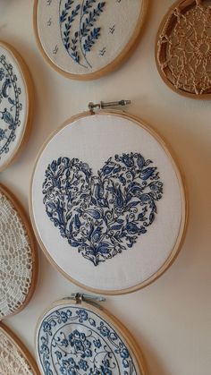 several blue and white embroiderys are hanging on the wall