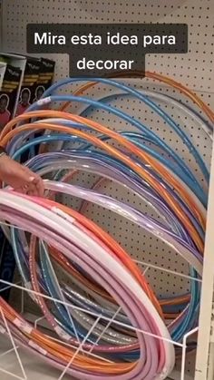 there are many different colored wires on the shelf in this store, and one is pointing at it