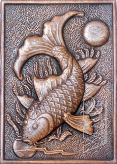 a metal plaque with a fish and moon on it