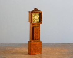 a small wooden clock sitting on top of a table