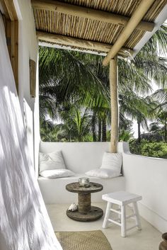 a porch with white furniture and palm trees