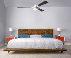a bedroom with a bed, two nightstands and a ceiling fan