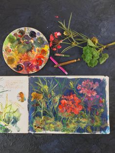 an artist's palette with flowers and butterflies on it next to a painting book