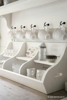 there are many cups on the shelves in this kitchen