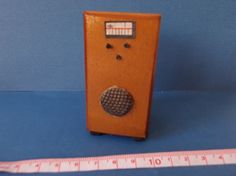 an old fashioned wooden radio next to a measuring tape