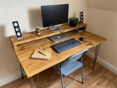 a computer desk with a keyboard, monitor and speakers