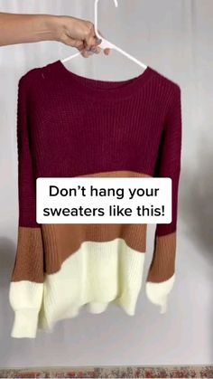 a woman holding up a sweater that says don't hang your sweaters like this