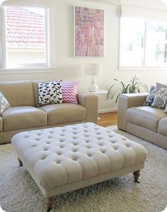 a living room with two couches and a footstool