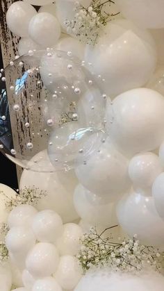 white balloons and greenery in front of a mirror