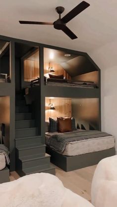 a room with three bunk beds in it and a ceiling fan on the other side
