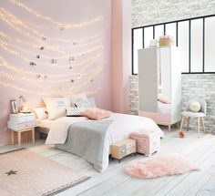 a bedroom with pink walls and white furniture