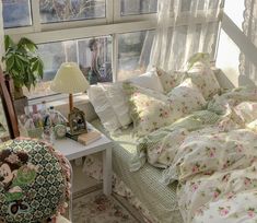 a bed with floral sheets and pillows in a bedroom next to a window that looks out onto the yard