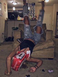 a woman laying on the floor with her legs up in the air while holding onto a bag