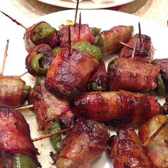 several skewered meats and peppers on a plate