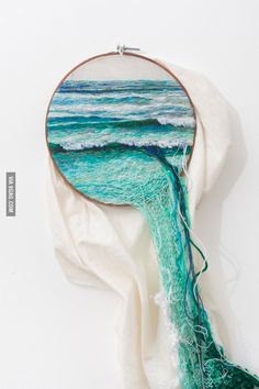 a piece of art that looks like an ocean wave coming out of the water, on top of a white cloth
