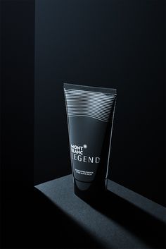a tube of cream sitting on top of a black table next to a dark background