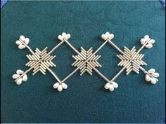 three pieces of silver metal with white flowers and leaves in the shape of snowflakes