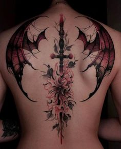 the back of a woman's body with an elaborate tattoo design on her ribs