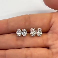 three pairs of diamond studs are shown in the palm of someone's hand