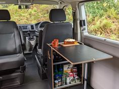 a table in the back of a van with food and drinks on it next to an open window
