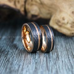 two gold and black wedding rings on top of each other