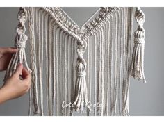 a person is holding up a macrame