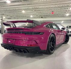 a pink porsche sports car parked in a garage