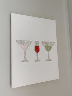 three wine glasses on a white canvas hanging on the wall